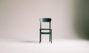 Large scrolling parallax image of a chair isolated in an empty room, representing the isolation we often feel when we need support.